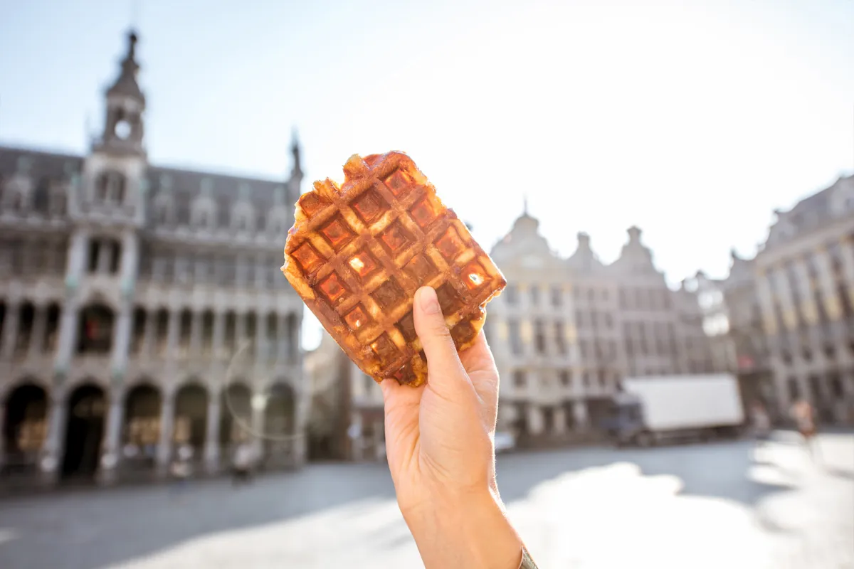 Main tenant une gaufre de Bruxelles sur la Grand Place